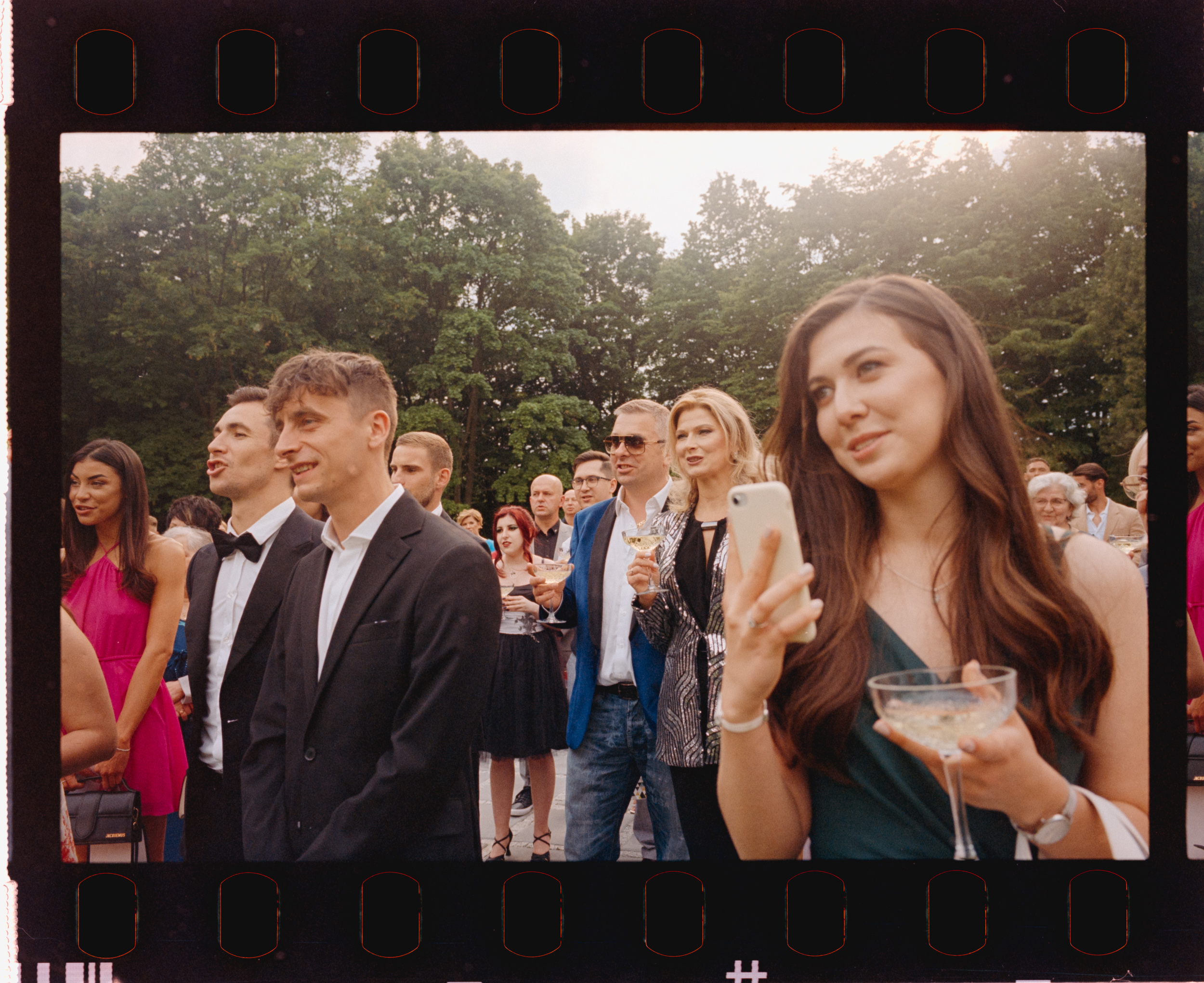 Goście podczas toastu w ogrodzie. Fotografia na filmie Kodak UltraMax.